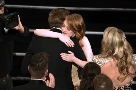 Ryan Gosling, right, congratulates Emma Stone as she accepts the award for best actress in a leading role for "La La Land" at the Oscars on Sunday, Feb. 26, 2017, at the Dolby Theatre in Los Angeles. (Photo by Chris Pizzello/Invision/ANSA/AP) [CopyrightNotice: 2017 Invision] 