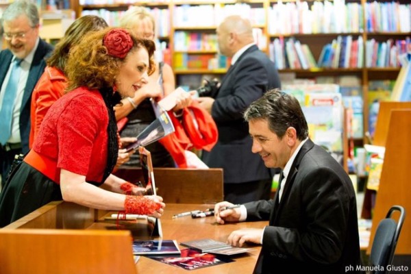 con una fan mentre firma autografi