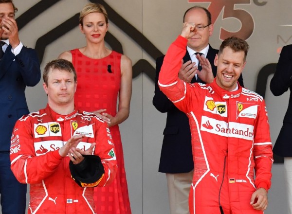 Winner Ferrari's German driver Sebastian Vettel (R) celebrates on the podium next to second placed Ferrari's Finnish driver Kimi Raikkonen after the Monaco Formula 1 Grand Prix at the Monaco street circuit, on May 28, 2017 in Monaco. / AFP PHOTO / Pascal GUYOT 
